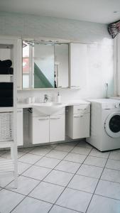 a white bathroom with a sink and a washing machine at Lieblingsapartment No.12 für bis zu 6 Gäste in Rostock
