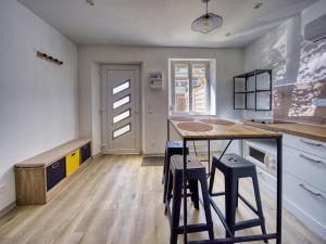 a kitchen with a counter and stools in it at 2 pièces indépendant à la campagne in Monchy-Lagache +2 photos