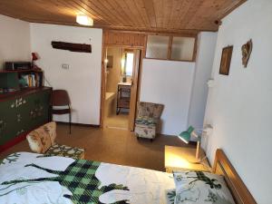 a bedroom with a bed and a living room at L'antico Maso in Mendola