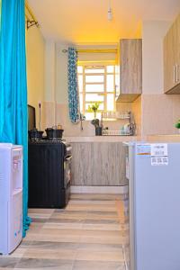 a kitchen with a white refrigerator and a stove at The Presidential Suite in Ruiru