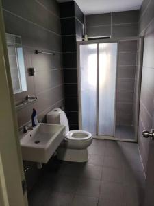 La salle de bains est pourvue de toilettes, d'un lavabo et d'une douche. dans l'établissement HB1516- Two queen bed-Wifi-Netflix- Parking- Cyberjaya, 3056, à Cyberjaya