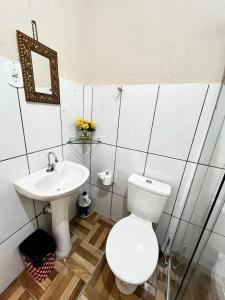 a bathroom with a white toilet and a sink at Divino Espírito Santo in Aparecida