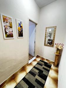 a room with a hallway with a mirror and a rug at Divino Espírito Santo in Aparecida