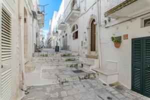 an alley with stairs and a green door at La Terrazza del Marinaio in Ostuni