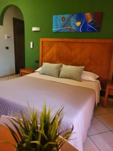 a bedroom with a large bed and two potted plants at Hotel Federico II in Castiglione di Sicilia