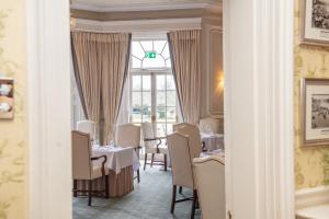 a dining room with tables and chairs and a window at Phyllis Court Members Club in Henley on Thames