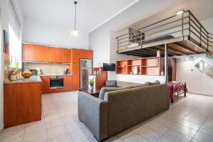 un salon avec un canapé et une cuisine dans l'établissement Rafaela's House, à Koskinou