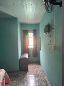 um quarto com uma cama, uma janela e uma cadeira em Chalé Agreste em Santana do Riacho