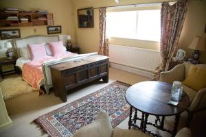 1 dormitorio con cama, mesa y ventana en The Old Bakehouse, Walsingham, en Little Walsingham