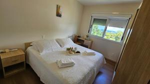 a bedroom with a bed with two towels on it at Pousada Bom Pastor in Caxias do Sul