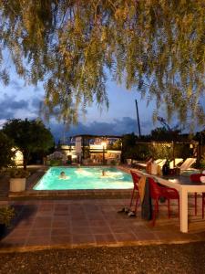 una piscina con dos personas nadando en ella por la noche en B&B Finca Alegria de la Vida en Pizarra