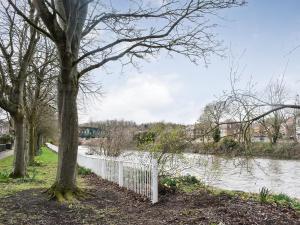 a white fence next to a river with trees at Riverside Hideaway in Washington