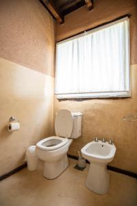 a bathroom with a toilet and a sink and a window at Brisas de Chacras in San Javier
