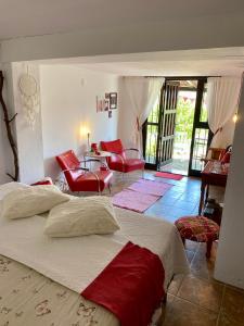 - une chambre avec un grand lit et des chaises rouges dans l'établissement B&B Finca Alegria de la Vida, à Pizarra