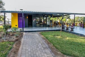 a building with a yellow and purple facade with a patio at SleepOver Beitbridge in Musina
