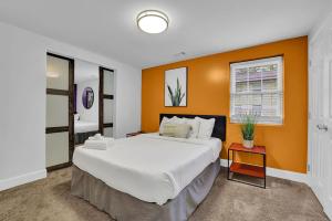a bedroom with a large bed with an orange wall at Blue Atlanta Magichottubpool10qn Bedsmessnow in Atlanta