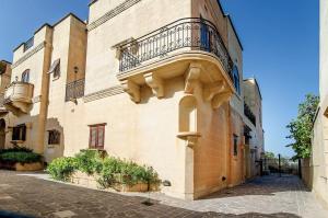 un edificio con un balcón en el lateral. en LeVecca Village House 1 - Gladiola, en Għasri