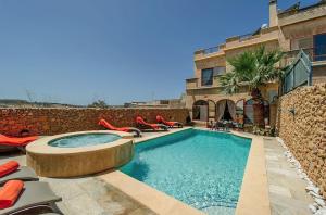 a swimming pool in front of a house at LeVecca Village House 1 - Gladiola in Għasri