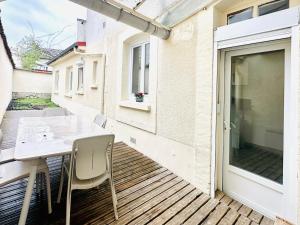 a patio with a table and chairs on a deck at Reims Sherpa Lodge in Reims