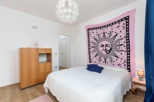 a bedroom with a white bed and a wall art at The White Villa in Tortolì +11 photos