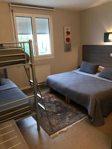 1 dormitorio con 2 camas y 1 litera en Hôtel Le Cerizay en Cerizay