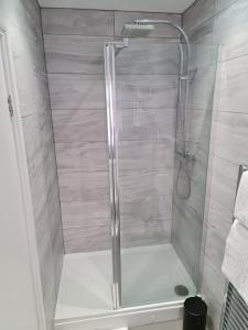 a shower with a glass door in a bathroom at Marden guest house in Weymouth