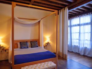 a bedroom with a canopy bed and a window at Casa del Armiño Mansión de la Familia de "El Greco" in Toledo