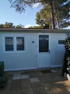 a white garage with two windows and a door at SOUS LE SOLEIL DE PROVENCE in Le Castellet