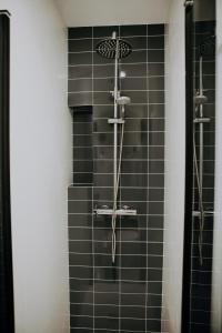 bagno con doccia e piastrelle nere di Vibes Coruña- Loft Adelaida a La Coruña