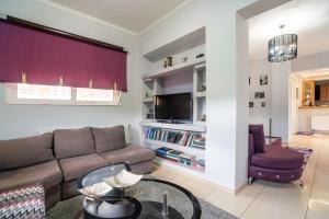 a living room with a couch and a table at Rafaela's House 2 in Koskinou