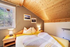 a bedroom with a bed and a wooden ceiling at Lingerhof Alpenrose in Meltina