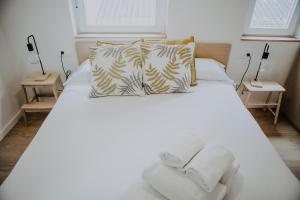 una camera con un letto bianco e 2 lampade di Vibes Coruña- Loft Adelaida a La Coruña