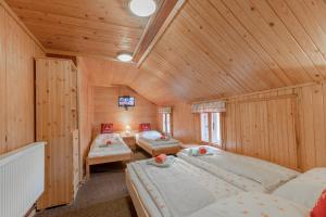 een slaapkamer met 2 bedden in een houten kamer bij Sagasserovy boudy U Dvou vleků in Pec pod Sněžkou