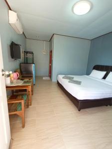 a bedroom with a bed and a desk and a television at บ้านทุ่ง เคียงบึง รีสอร์ท in Ban Don Klang