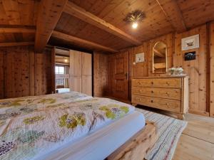 a bedroom with a bed and a dresser in a cabin at Ferienwohnung am Fuschlsee in Fuschl am See