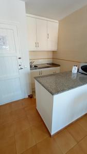 a kitchen with white cabinets and a counter top at Costa Arenal 112 in Arenal d'en Castell
