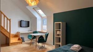 Hotel77 في زاموسك: غرفة نوم بحائط لكنة خضراء وطاولة وكراسي