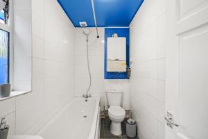a bathroom with a toilet and a bath tub at 3BR Stylish Modern House Oxford in Oxford