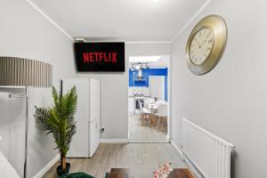 a hallway with a clock on the wall and a dining room at 3BR Stylish Modern House Oxford in Oxford