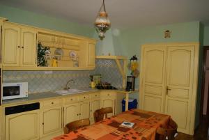 a kitchen with white cabinets and a table with a microwave at Durand Yves in Régnié