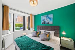 Dormitorio verde con cama con pared verde en 3BR Stylish Modern House Oxford en Oxford