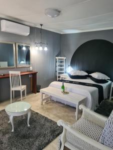 a bedroom with a bed and a table and chairs at Prosper Stud Guest House in Robertson