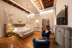 a bedroom with a bed and two blue chairs at Ricasoli Garden Relais in Florence