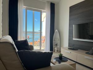 a living room with a couch and a television at Apartman Maja in Selce