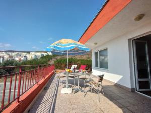 a patio with a table and an umbrella on a balcony at Apartament Panorama - BastetBS in Sveti Vlas