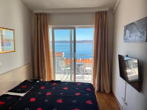 a bedroom with a bed and a view of the ocean at Apartman Maja in Selce