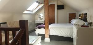 a attic bedroom with a bed and a mirror at Ugiebrae House Bed & Breakfast in Seahouses