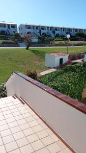 een witte muur naast een veld met gebouwen bij Costa Arenal 112 in Arenal d'en Castell