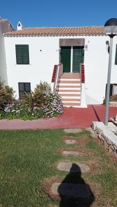 a shadow of a person standing in front of a house at Costa Arenal 112 in Arenal d'en Castell