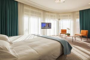 a bedroom with a large white bed and green curtains at Vincci Porto in Porto